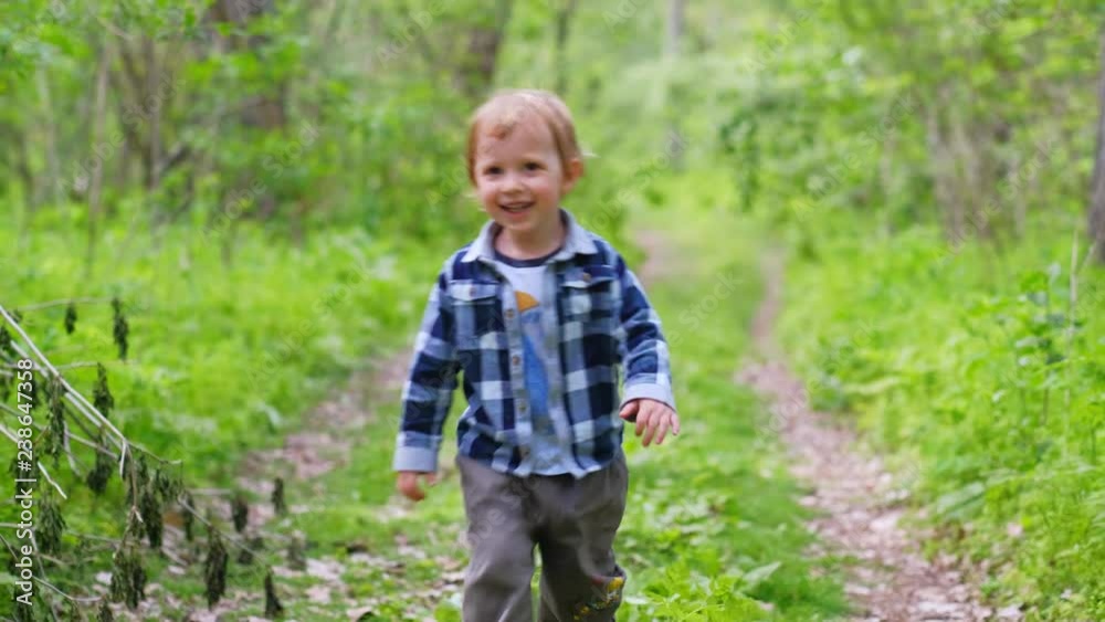 Happy kid boy travel with family outdoors on nature, running and playing. Child with parents spend summer holidays in park. Happy kid boy travel with family outdoors on nature, running and playing. Child with parents spend summer holidays in park.