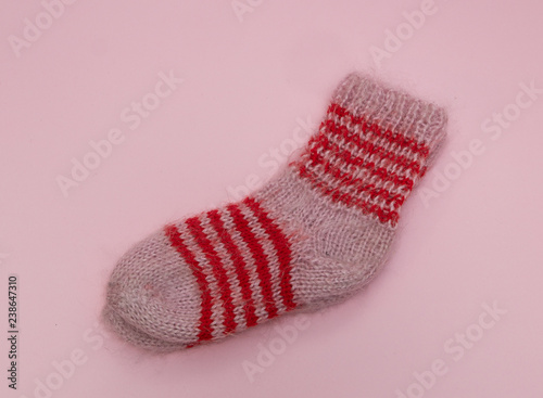 handmade woolen merino wool socks on pink rose background. craft store concept