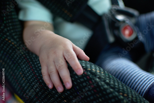 Baby place his hand on the car seat and sit calm. Baby sit in rear facing car seat.