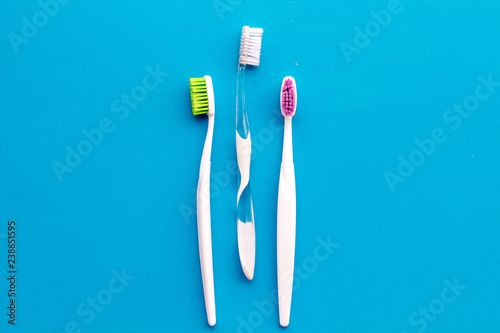 Daily oral hygiene for family. Toothbrush on blue background top view mock up