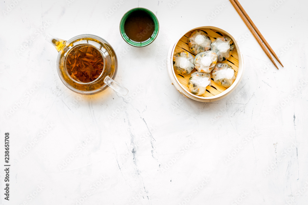 Dim sums with sticks and herbal tea in Chinese restaurant on marble background top view mockup - obrazy, fototapety, plakaty 