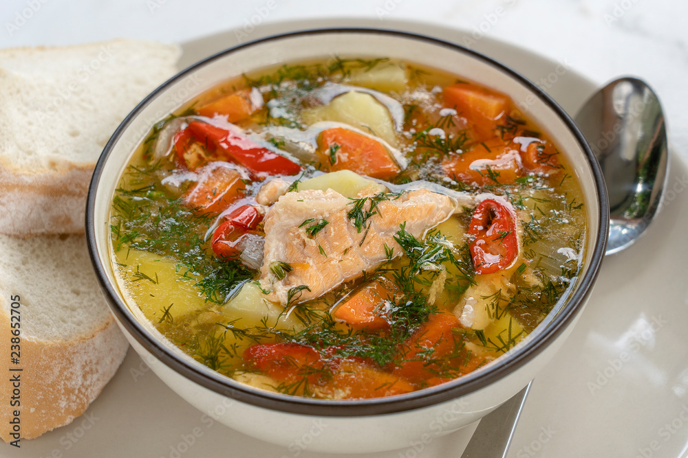 Salmon soup with potatoes, carrots, dill, pepper in bowl, close up Salmon soup with potatoes, carrots, dill, pepper in bowl, close up