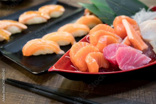 Mixed sliced fish sashimi on ice in white bowl. Sashimi Salmon Tuna Hamachi set, raw fish, japanese food in Asian restuarant.