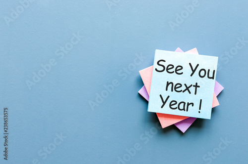 Foto Business message See You Next Year written in message at blue table in backgroun