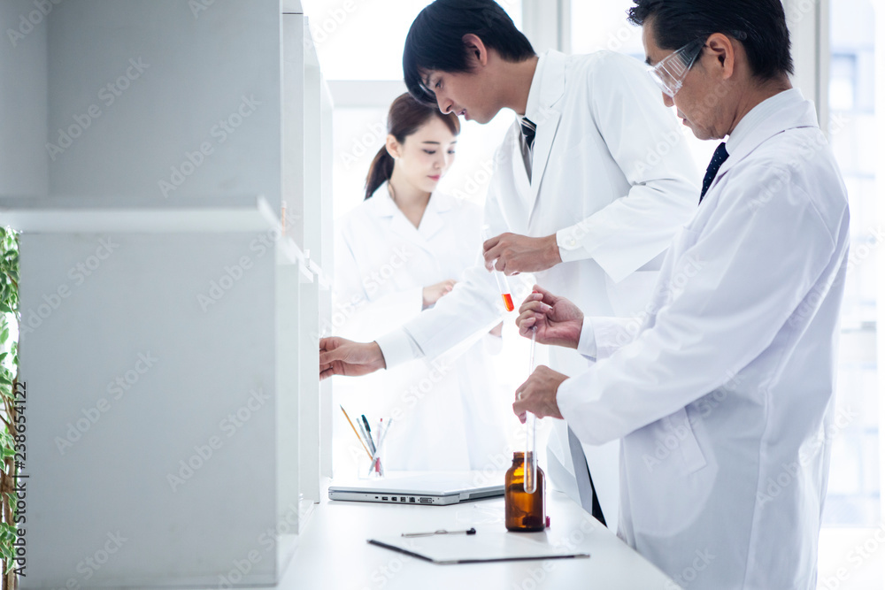 科学者たちが記録をとりながら実験を進めている 科学者たちが記録をとりながら実験を進めている