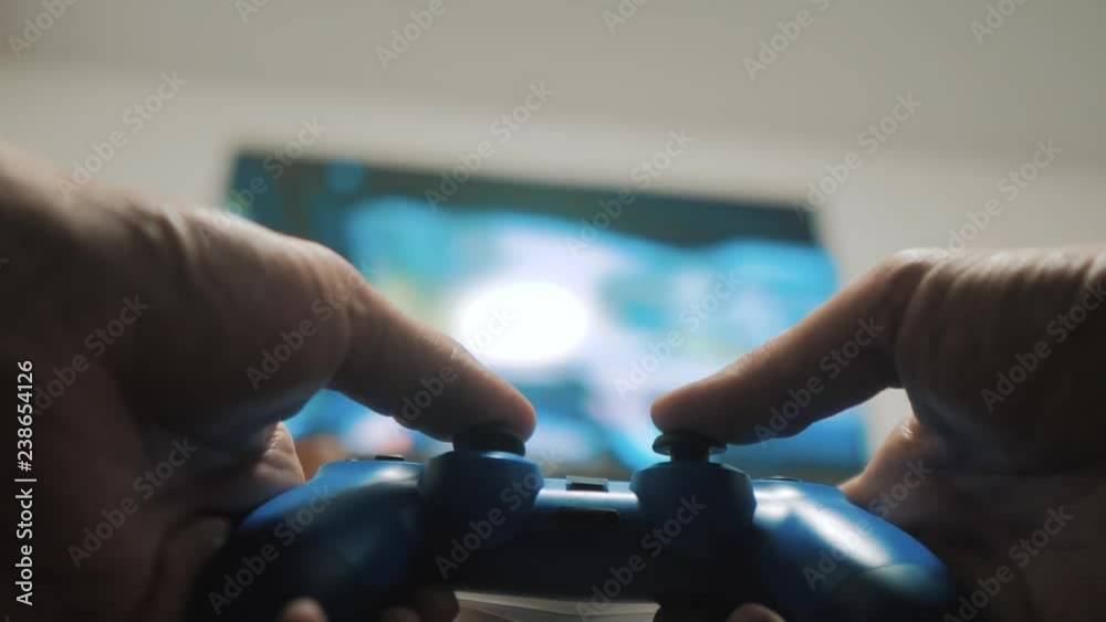playing video console on tv. Hand hold new joystick playing lifestyle video console on tv. Gamer play game with gamepad controller. Gaming man holding simulator joypad. Person with keypad joystick in playing video console on tv. Hand hold new joystick playing lifestyle video console on tv. Gamer play game with gamepad controller. Gaming man holding simulator joypad. Person with keypad joystick in