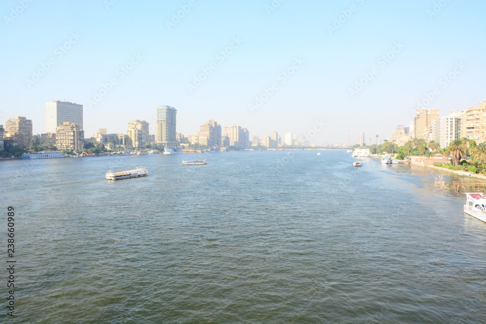 Nile river in Cairo Egypt during the day with boats running and high building surrounding river banks Nile river in Cairo Egypt during the day with boats running and high building surrounding river banks