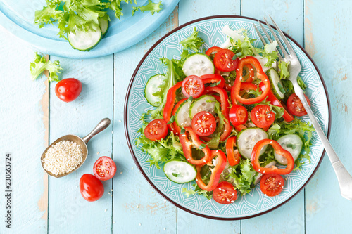 Healthy vegetarian vegetable salad of fresh lettuce, cucumber, sweet pepper and tomatoes. Vegan plant-based food. Flat Lay. Top view