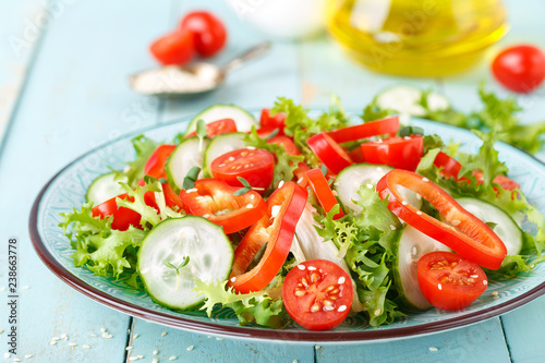 Healthy vegetarian vegetable salad of fresh lettuce, cucumber, sweet pepper and tomatoes. Vegan plant-based food. Flat Lay. Top view