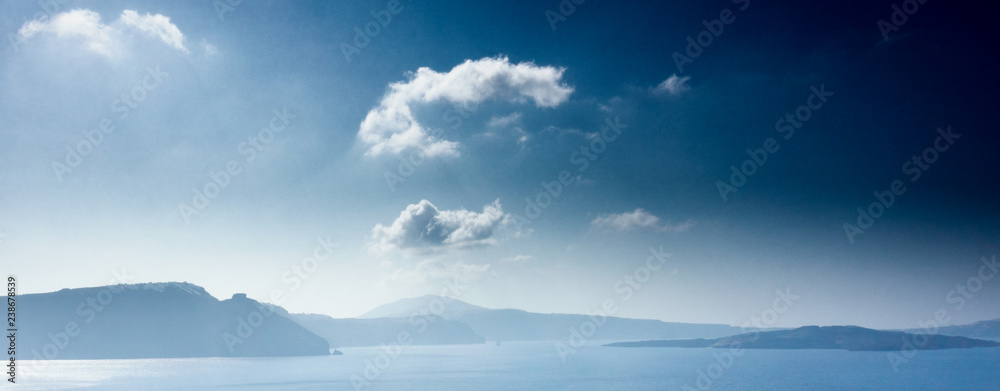 Scenic view of mountain and Santorini island against cloudy sky; Greece