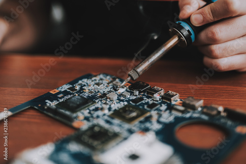 Close up. Man Repairing Motherboard from Laptop.