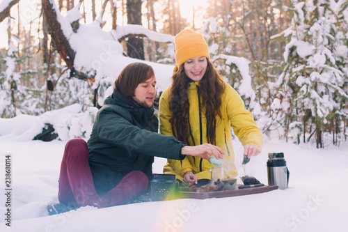 couple in love holds a tea ceremony in the winter forest