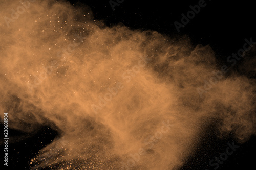 abstract brown powder splatted background. Colorful powder explosion on black background. Colored cloud. Colorful dust explode. Paint Holi.