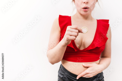 Close up of a young girl holding an open condom, safe sex concept.
