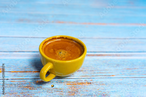 Yellow cup of hot coffee.