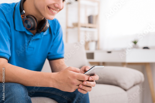 Teenager watching funny videos on smartphone at home