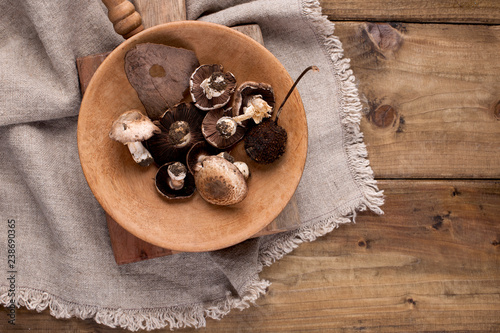 Mushrooms in a pan on a wooden background. Vintage photo and napkin in rustic style. Free space for text, top view.