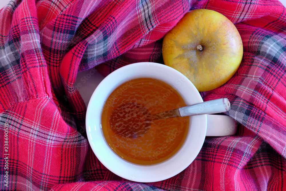 Tee Tasse mit Apfel in kariertem Tuch Tee Tasse mit Apfel in kariertem Tuch