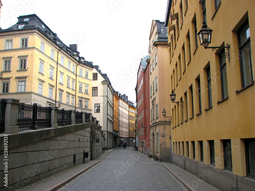 Fototapeta Naklejka Na Ścianę i Meble -  Deserted pedestrian street in the old part of Stockholm, Sweden. Colorful houses with vintage lanterns.