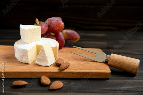 Cheese and grapes on a dark background
