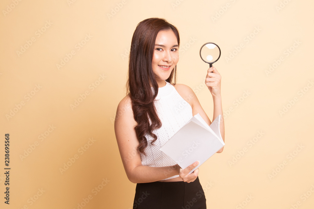 Obraz premium Asian woman with a book and magnifying glass.