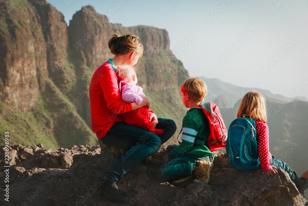 family with kids travel hiking in mountains looking at view