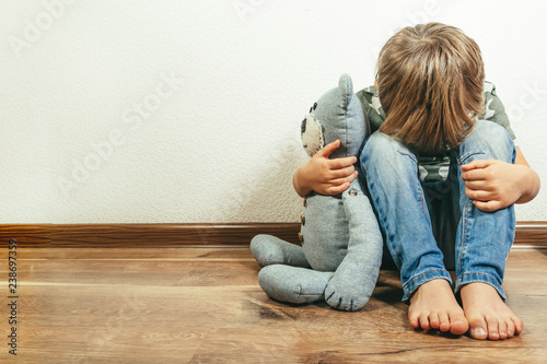 Sad depressed boy with teddy bear