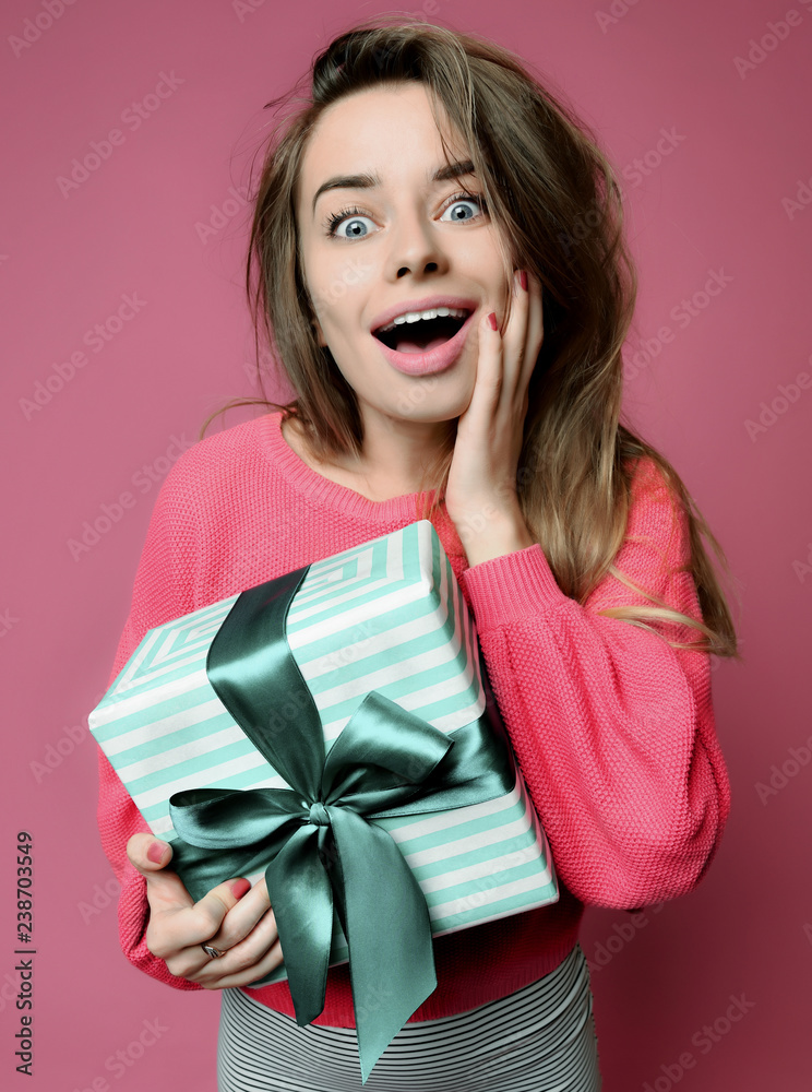 Beautiful young woman hold pastel green color Christmas presents gift box for new year or birthday surprised Beautiful young woman hold pastel green color Christmas presents gift box for new year or birthday surprised