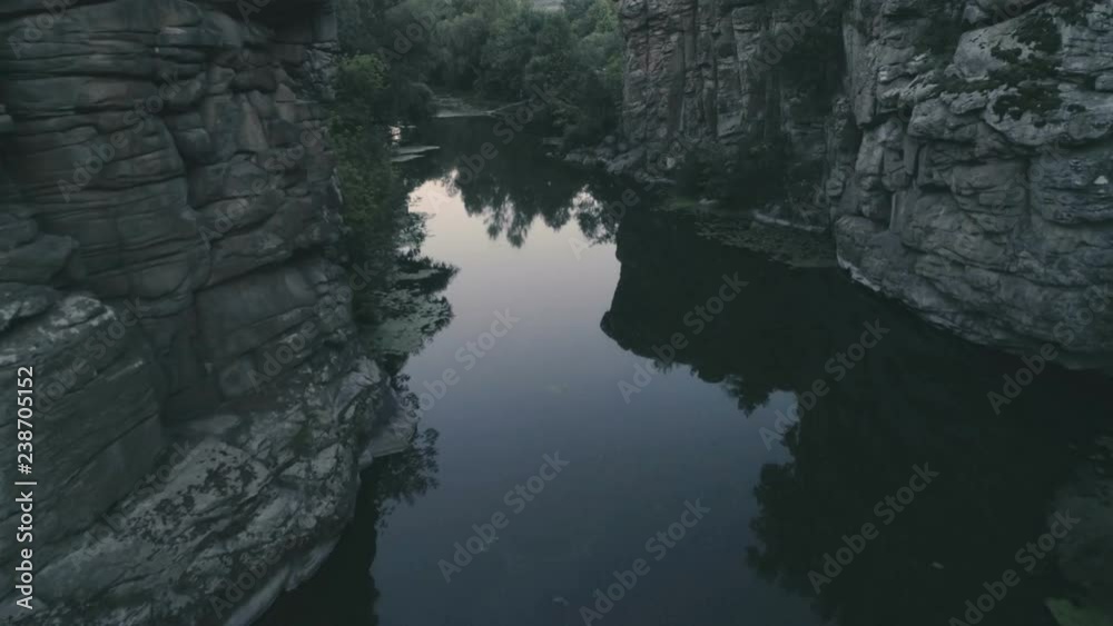 Narrow brook flowing between two stony rocks in the evening in summer Narrow brook flowing between two stony rocks in the evening in summer