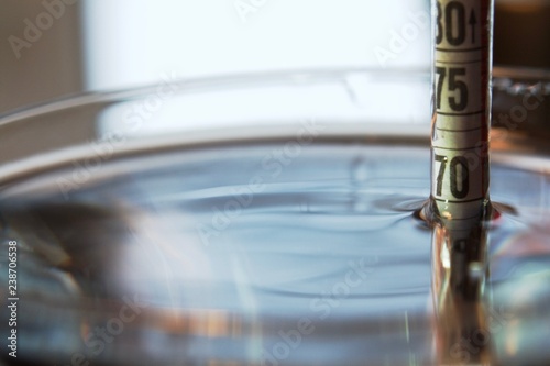 the alcohol meter is immersed in liquid - shows 70 degrees photo