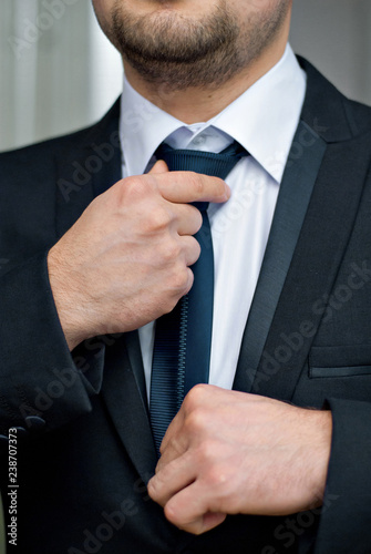 The bridegroom is dressed for a wedding ceremony. Hands and costume close-up.