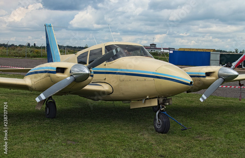 The two engine plane stands on the green grass in a cloudy day. A small private airfield in Zhytomyr, Ukraine