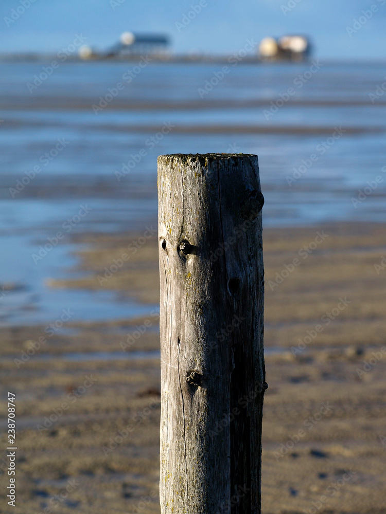 Einzelner Holzpfahl am Strand in Sankt Peter-Ording Einzelner Holzpfahl am Strand in Sankt Peter-Ording