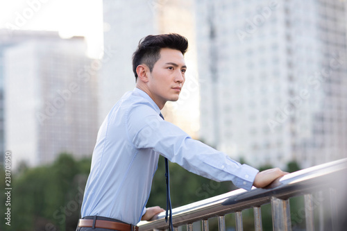 Confident young businessman thinking