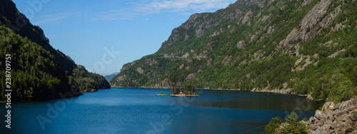 Panorama of Lovrafjorden with typical red painted Norvegian house building on a tiny small island in the middle