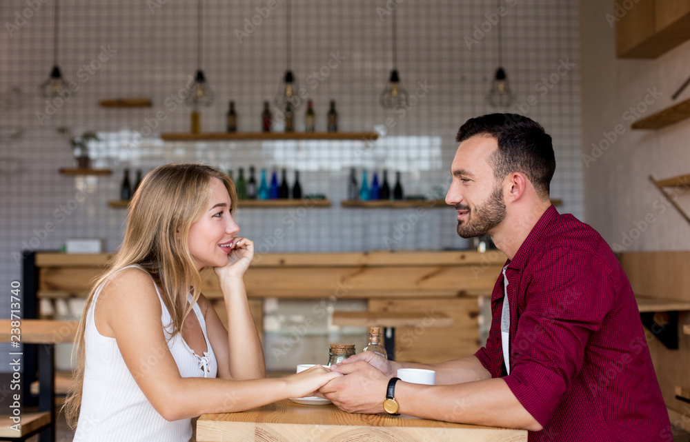 Fototapeta premium Cute couple having coffee together in cafe