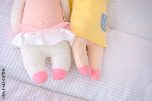 A partial of closeup legs dolls in the kid bed.