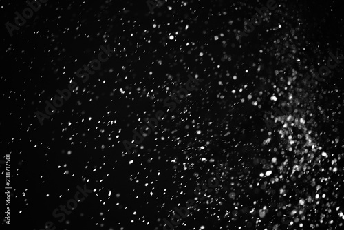 Falling snow on a black background. Snowfall weather. Texture for overlay