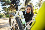 Attractive fit sportswoman having to fix her bicycle at the park