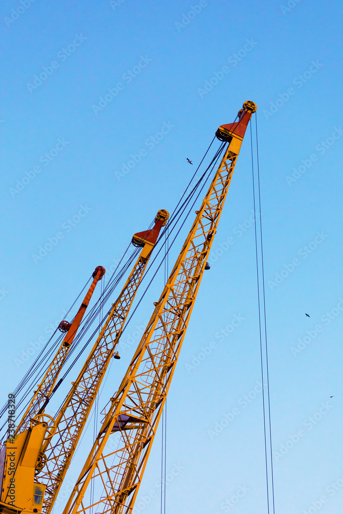 Cargo port cranes on a background of blue sky Cargo port cranes on a background of blue sky