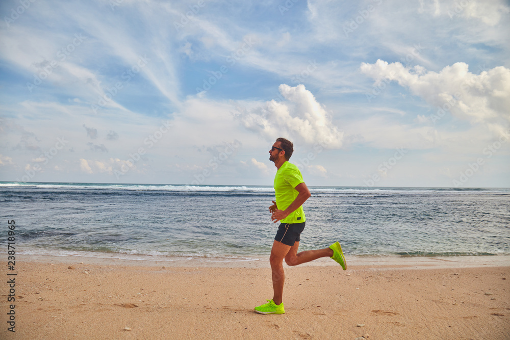 Man running / jogging on a tropical exotic beach.