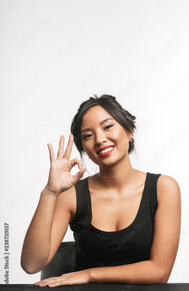 Pretty young asian woman sitting at the table Pretty young asian woman sitting at the table