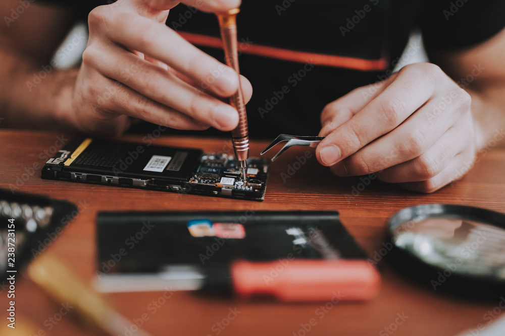 Close up Young Man Repairing Mobile Phone at Table Close up Young Man Repairing Mobile Phone at Table