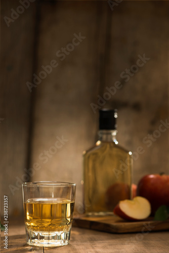 Bottle and glass of natural apple juice and sections of apple