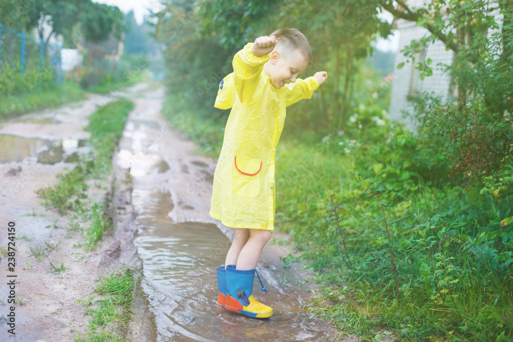 child in rubber boots playing in a puddle child in rubber boots playing in a puddle