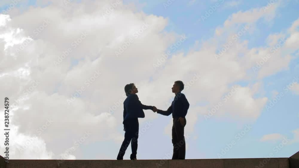 Wide shot of male and female Asian business people going towards each other, shaking hands and thus making a deal Wide shot of male and female Asian business people going towards each other, shaking hands and thus making a deal