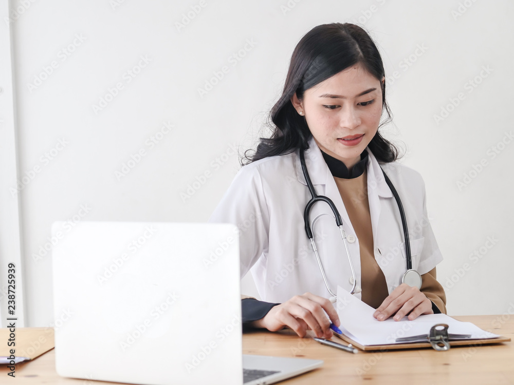 Female Asian doctor working at office desk, lifestyle concept. Female Asian doctor working at office desk, lifestyle concept.