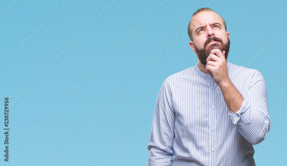 Young caucasian hipster man over isolated background with hand on chin thinking about question, pensive expression. Smiling with thoughtful face. Doubt concept. Young caucasian hipster man over isolated background with hand on chin thinking about question, pensive expression. Smiling with thoughtful face. Doubt concept.