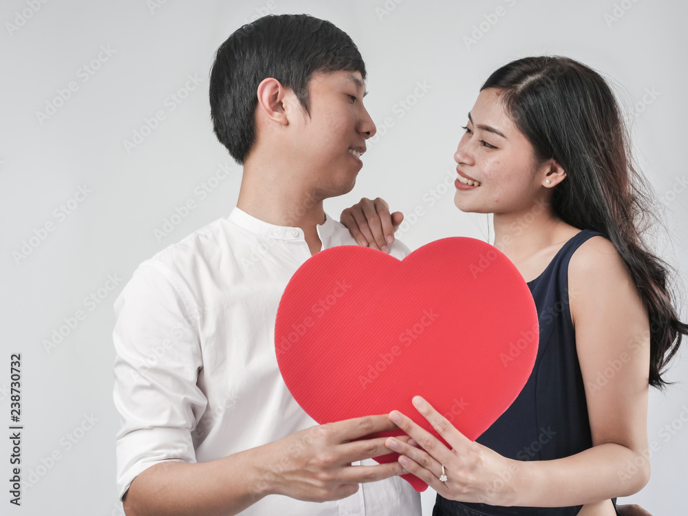 Happy couple in love holding red heart shape, valentine concept.
