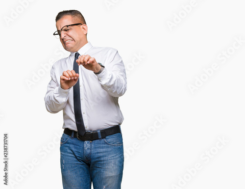 Middle age bussines arab man wearing glasses over isolated background disgusted expression, displeased and fearful doing disgust face because aversion reaction. With hands raised. Annoying concept. © Krakenimages.com